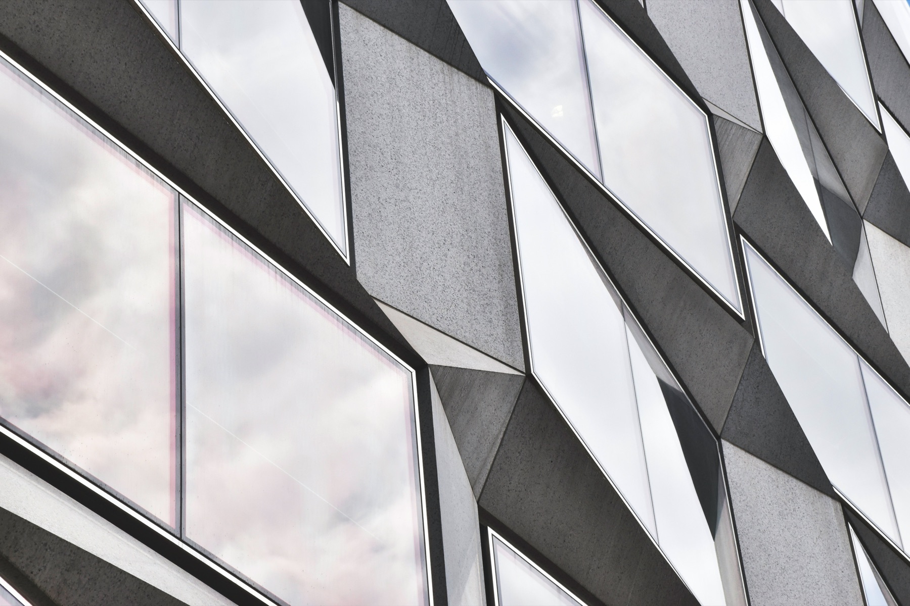 A modern glass facade over a classical stone building